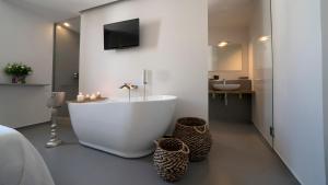 a bathroom with a tub and a sink and a television at New Dimora Valmar in Polignano a Mare