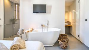 a bathroom with a white tub and a tv on the wall at New Dimora Valmar in Polignano a Mare