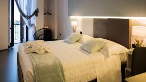 a bedroom with a white bed with towels on it at New Dimora Valmar in Polignano a Mare