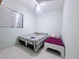 ein kleines Zimmer mit einem Bett und einem Fenster in der Unterkunft Apartamento completo Condomínio Caribe Ubatuba in Ubatuba + 14 Fotos