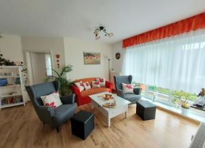 a living room with a couch and chairs and a table at Ferienwohnung Mohnblume in Sassnitz