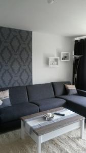 ein Wohnzimmer mit einer blauen Couch und einem Couchtisch in der Unterkunft Fewo 8 Steffens in Goslar