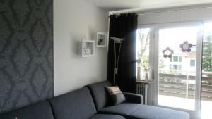 ein Wohnzimmer mit einem blauen Sofa und einem Fenster in der Unterkunft Fewo 8 Steffens in Goslar + 9 Fotos