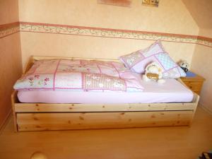 a bed with two teddy bears sitting on top of it at Ferienwohnung PANTEN in Neukirchen +5 photos