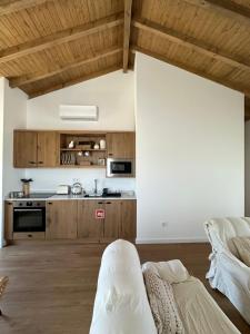 a kitchen with wooden cabinets and a couch in a room at Casas da Pereira in Barcos