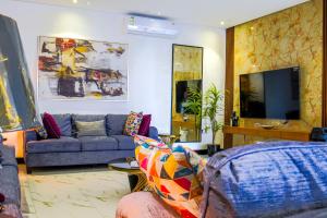 a living room with a couch and a tv at The Land Resort in Riyadh