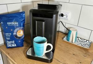 a coffee maker sitting on a counter with two cups at Stadt-Ferienwohnung in Bad Lauterberg