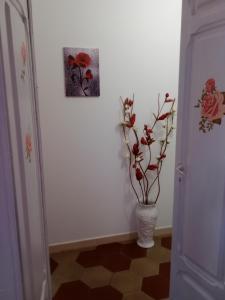 a hallway with a vase with flowers in it at Appartamento vacanze Le rose in Bosa