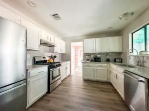 een keuken met witte kasten en witte apparaten bij The Cowboy Cabana in Round Rock