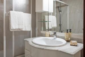 une salle de bains blanche avec un lavabo et un miroir dans l'établissement Biarritz - Varanda da Ria, à Costa Nova 19 autres photos