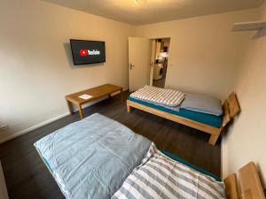 a room with two beds and a tv on the wall at Ferienwohnung Osnabrück- Schinkel in Osnabrück