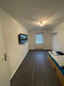 a bedroom with a bed and a television on the wall at Ferienwohnung Osnabrück- Schinkel in Osnabrück