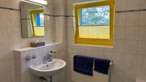 bagno con lavandino, specchio e asciugamani blu di Franzi 1 a Prerow