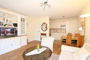 un salon avec une table et une salle à manger dans l'établissement Haus Alice - Segatz 36/2, à Westerland