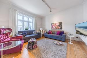 a living room with two couches and a tv at Die Schlosserei in Westerland
