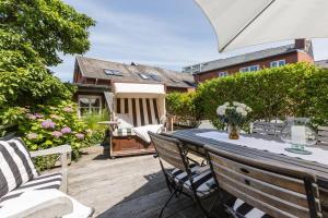 a patio with a table and chairs on a deck at Die Schlosserei in Westerland