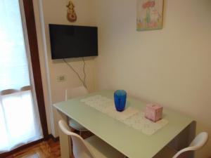 a room with a table with chairs and a tv at Podere Luma Camera Roseto - Mimosa in Gambassi Terme