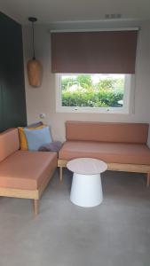 a living room with two couches and a table at Campingland Ostsee - Mobilheim 76Strandhafer NEU! in Schashagen