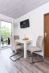 ノイハルリンガージールにあるFerienwohnungen Haus Boje "Krabbe"のテーブルと椅子と窓のある部屋