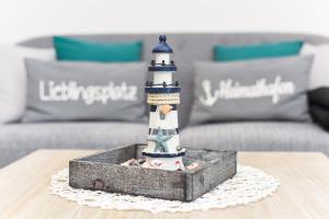 ノイハルリンガージールにあるFerienwohnungen Haus Boje "Krabbe"のソファの前の灯台置物