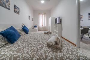a living room with a large bed with blue pillows at Gioia del Corso in Iesi