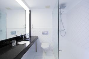 a bathroom with a toilet and a sink and a shower at Windeby 4E in Wenningstedt
