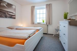 a bedroom with two beds and a window at Knusthof Lafrenz - Apfelhofblick in Fehmarn