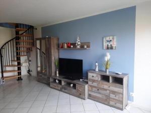 a living room with a tv on a blue wall at Haus Sonnenstrahl 11 in Dorum-Neufeld
