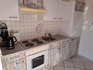 a kitchen with a sink and a stove top oven at Haus Sonnenstrahl 11 in Dorum-Neufeld