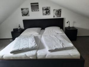 a large bed with white sheets and pillows on it at Haus Sonnenstrahl 11 in Dorum-Neufeld +9 photos
