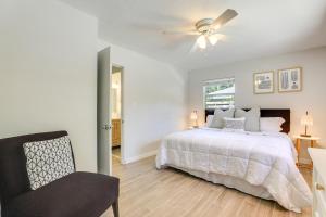 a bedroom with a bed with a ceiling fan and a chair at Boho-Chic Sarasota Hideaway Yard and Fire Pit! in Sarasota