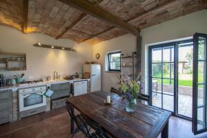 a kitchen with a wooden table and a wooden ceiling at Scheune Zauchwitz in Beelitz