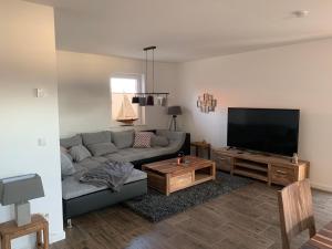 a living room with a couch and a flat screen tv at Achter Wiek in Kühlungsborn +17 photos