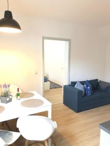 a living room with a blue couch and a table at "Ahrenshoop" in Prerow