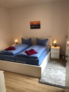 a bedroom with two beds with blue sheets and red pillows at "Ahrenshoop" in Prerow
