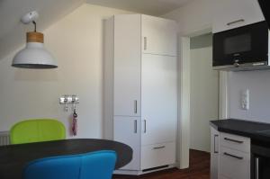 a kitchen with a table and chairs and a cabinet at Am Alten Leuchtfeuer in Eckernförde