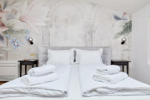 a bedroom with a white bed with towels on it at TUDISI LUX SUITES by DOMINIUM in Dubrovnik