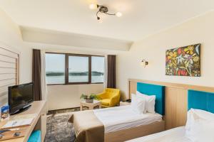 ガラツィにあるFaleza Hotel by Vegaのベッド2台とテレビがあるホテルの部屋