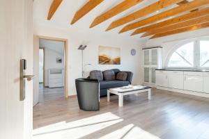 a living room with a couch and a table at Ferienwohnung Seestern mit Rundbogenfenster am Badesee Tannenhausen in Aurich