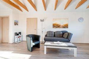 a living room with a couch and a table at Ferienwohnung Seestern mit Rundbogenfenster am Badesee Tannenhausen in Aurich