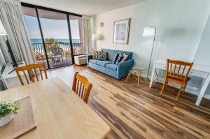 un salon avec un canapé bleu et une table dans l'établissement Romantic Oceanfront View, Discounted, Pools, à Myrtle Beach