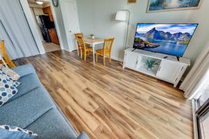 un salon avec un canapé, une télévision et une table dans l'établissement Romantic Oceanfront View, Discounted, Pools, à Myrtle Beach