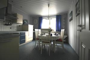 a kitchen with a table and chairs in a kitchen at Ferienhaus Brigitte in Dornum