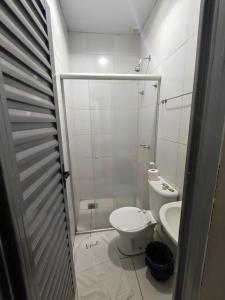 a small bathroom with a toilet and a shower at Shopping 44 Hotel in Goiânia +6 photos