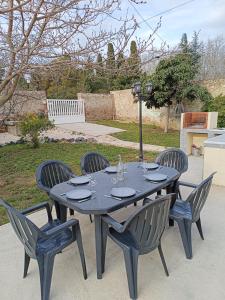 a black table with four chairs around it at Maison 6 pers, avec jardin, clim et pétanque in Thuir
