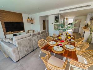a living room with a table with chairs and a couch at Villa Murcia - Private heated pool & jacuzzi in Santiago de la Ribera