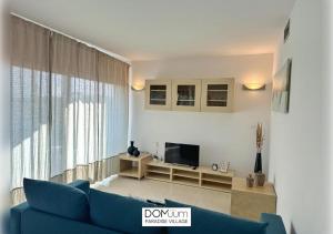 een woonkamer met een blauwe bank en een televisie bij DOMuum Holidays - PARADISE VILLAGE in Salou +22 foto's