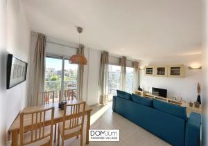een woonkamer met een blauwe bank en een tafel bij DOMuum Holidays - PARADISE VILLAGE in Salou