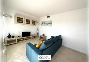 een woonkamer met een blauwe bank en een tv bij DOMuum Holidays - PARADISE VILLAGE in Salou