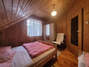 a bedroom with a bed in a wooden room at Domek Letniskowy - Jerutki in Jerutki